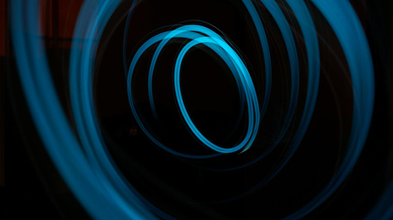 Illustration of sweeping blue intertwined circles on black background